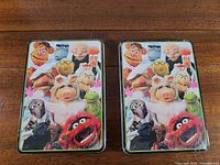 Front view of both Muppets activity tins