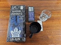 Lot overview showing boxed slippers, stick box, mug, glass and tags