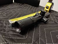 Side view of Monstrum scope with tape measure for scale