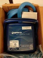 Top view of Breg Polar Care Cube in box with hose visible