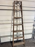 Front view of full ladder leaning against wall