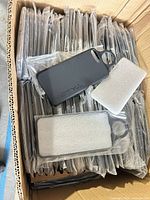 Open box filled with individually bagged Talon phone cases, two cases displayed showing front with foam and back logo