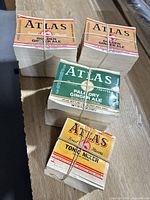 Overview of four bundled stacks of Atlas paper bottle labels
