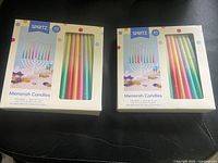 Front view of both Spritz menorah candle boxes showing pastel candles through window