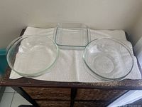 Two clear glass Pyrex bowls and one square clear glass baking dish displayed together