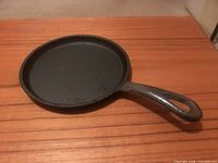 Full view of cast iron griddle showing handle and cooking surface
