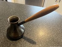 Side view showing copper body and wooden handle