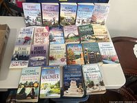All 21 Debbie Macomber paperbacks laid out on table