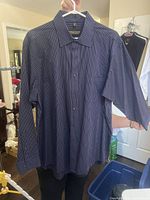 Front view of the pinstripe dress shirt on hanger