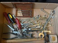 Overview of box with wrenches, larger screwdrivers, pliers, hammer head and precision set