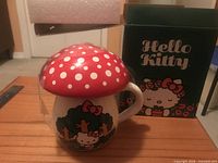 Mug with mushroom lid next to original Hello Kitty box