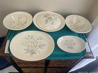 Five visible pieces: large platter, two bowls, covered serving dish with lid, small oval platter