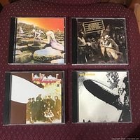 All four Led Zeppelin CD albums displayed on maroon fabric