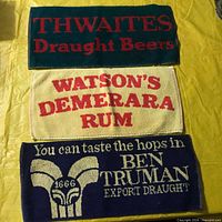 Three branded terry cloth bar mats laid out