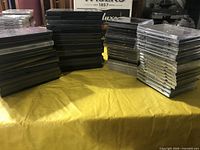 Stacks of DVD and CD cases on table