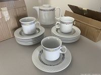Full set displayed: teapot, stacked saucers, cups