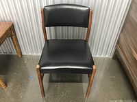 Front view of teak chair showing black seat and back