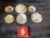 Entire lot displayed: lidded sugar bowl, two teacups with saucers, three leaf dishes, boxed ornament