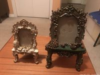 Front view of both ornate resin photo frames on tabletop