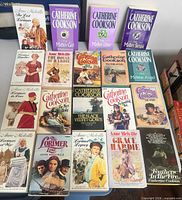 All 19 paperback novels laid out in three rows