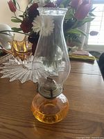 Full view of oil lamp on table showing chimney, burner, hobnail font