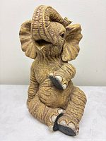Front view of resin elephant figurine in seated pose