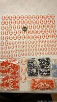 Overall view of laid-out red/ivory cameos with additional bagged cameos