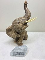 Elephant figurine and engraved plaque on tabletop