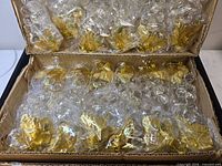 Box showing two layers of individually wrapped crystal grape ornaments