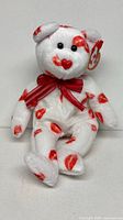 Front view of white bear with red kiss prints, ribbon, Ty tag visible