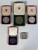 Five medallions displayed in open cases