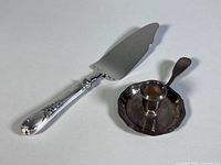 Both Christofle items together: cake cutter and chamberstick