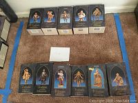 Arranged view of 11 Fontanini villager figurines all in original boxes, labeled with names and Roman Inc. branding