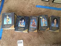 Five Fontanini figurines in original boxes laid out on floor. Boxes show distinct artwork with names: Levana & Barak, Phoebe, Samantha, Daphne, and Dominica.