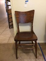 Full view of the vintage wood chair showing the backrest with lifting hole and wood grain.