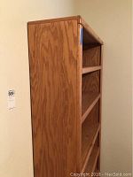 Side view of wood bookcase showing overall height and grain texture on wood.
