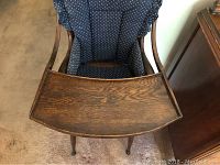 Front-top view showing wooden high chair tray and polka dot cushion inside the seat.