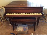 Front view of piano, bench and tote of songbooks