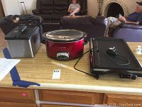 Shows Presto ProFry deep fryer on the left, 15 inch red Crock-Pot in the middle, and black electric griddle with cooking plate and control on the right, all on kitchen counter.