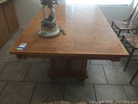 Top view showing wood grain pattern and pedestal base of table.