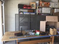 Wide shot of train pieces, track sections, and accessories on a workbench surface.