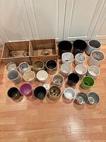 Group shot of 26 pots and 2 crates on floor