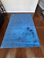 Top view of entire blue gradient rug on hardwood floor