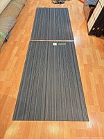 Two blue skinny stripe Chilewich mats laid end to end on wood floor