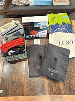 Full lot view showing stool box, roll-top cooler bags, LCBO tote, tropical cooler, box of zip pouches