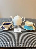 Lot overview showing both teacup sets and teapot