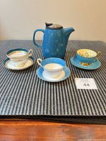 Group shot of three teacup and saucer sets with Tealyra teapot