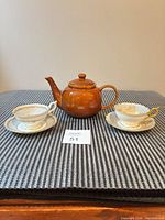 Wide shot showing both Coalport teacup sets and Brown Betty teapot