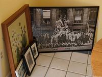 Group of framed artworks leaning against wall