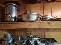 Overall lot on shelf showing percolator, large bowl, pots, pans, baking sheet